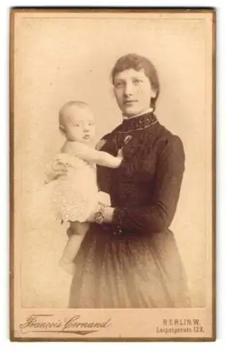 Fotografie Francois Cornand, Berlin, Mutter im dunklen Kleid mit ihrem Kind im Arm, Mutterglück