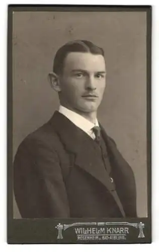 Fotografie Wilhelm Knarr, Rosenheim, Innstr. 42, Hans Kischinger im schwarzen Anzug mit feinem Schnurrbart und Krawatte