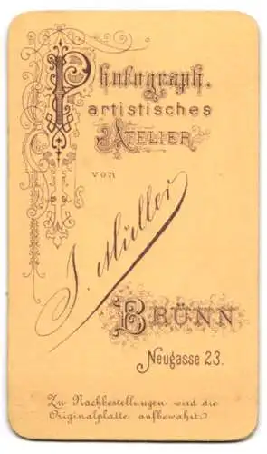 Fotografie Atelier Müller, Brünn, Neugasse 23, Niedlicher Bursche Max im schwarzen Anzug mit Anstecknadel und Krawatte