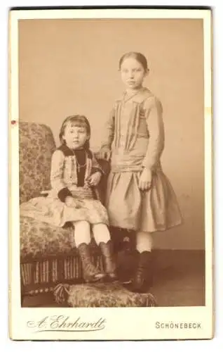 Fotografie A. Ehrhardt, Schönebeck, Salzerstr. 24, Emmy und Elly Wallstab in hellen Kleidern auf einem Sessel