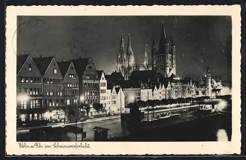 AK Köln a. Rh., Strassenpartie mit Kirche im Scheinwerferlicht
