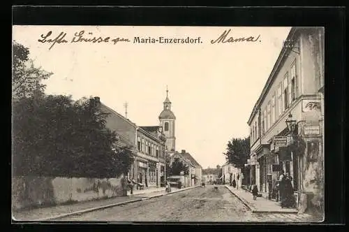AK Maria-Enzersdorf, Strassenpartie mit Geschäften und Kirchturm