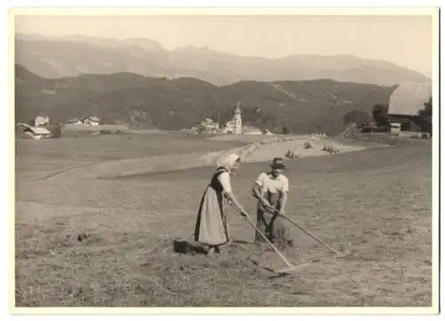 Fotografie unbekannter Fotograf, Ansicht Kastelruth, Bauernpaar bei der Arbeit am Ortsrand