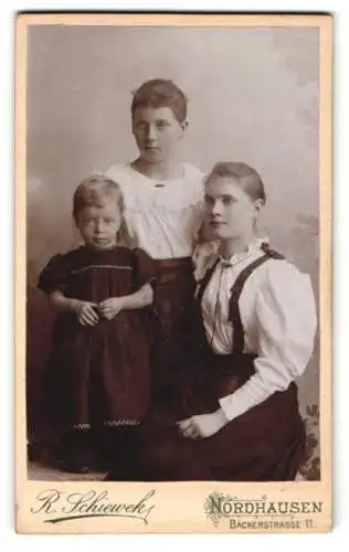 Fotografie R. Schieweck, Nordhausen, Bäckerstrasse 11, Zwei junge Mädchen in weissen Blusen mit einem Kind im Kleidchen