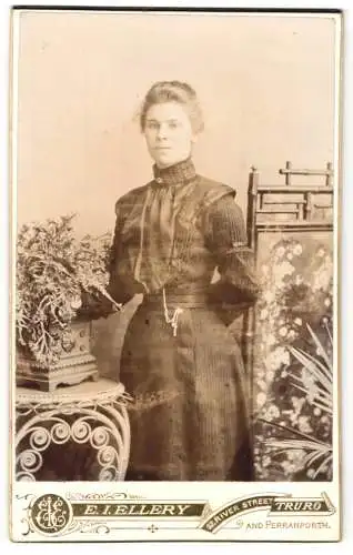 Fotografie E. I. Ellery, Truro, 32 River Street, Junge Frau im dunklen taillierten Kleid mit einer Hand hinterm Rücken