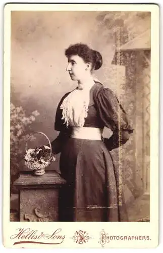 Fotografie Hellis & Sons, London, 211 /213 Regent Street, Junge Frau im taillierten Kleid mit einem Korb Blumen