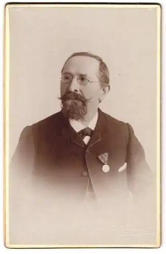 Fotografie E. Schmieder, Ort unbekannt, Friedrich Klein im Anzug mit einer Medaille, mit Brille und markantem Bart