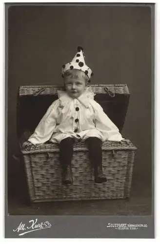 Fotografie Alb. Kurz, Stuttgart, junger Knabe als Clown im Kostüm verschwindet in einer Kiste, Fasching, 1907