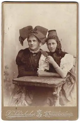 Fotografie X. Schönbucher, Donaueschingen, zwei Damen in Tracht mit kopfschleife und Hut