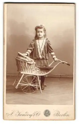 Fotografie A. Jandorf & Co., Berlin, junges Mädchen mit ihrem Puppenwagen im Atelier
