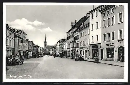 AK Mattighofen /O.-Oe., Strassenpartie mit Geschäften und Kirche
