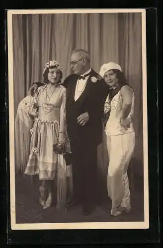 Foto-AK Mann mit zwei kostümierten Frauen zum Theaterball Fest in Rot
