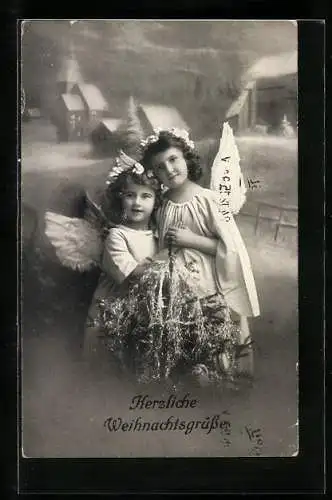 AK Kleine Weihnachtsengel halten sich hinter einem Christbaum im Arm