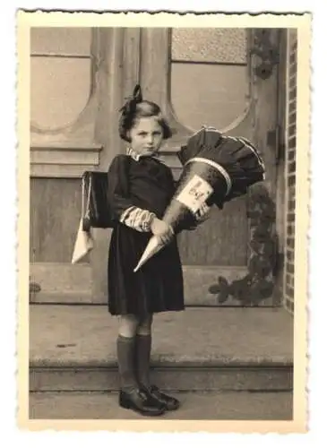 Fotografie Einschulung, niedliches Mädchen mit Schultüte am ersten Schultag