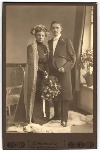 Fotografie Ed. Wolleschak, Weissenfels a. S., Ehepaar im schwarzen Brautkleid und Anzug mit Chapeau Claque