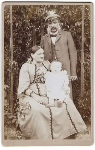 Fotografie unbekannter Fotograf und Ort, Älteres Paar mit Kleinkind in modischer Kleidung