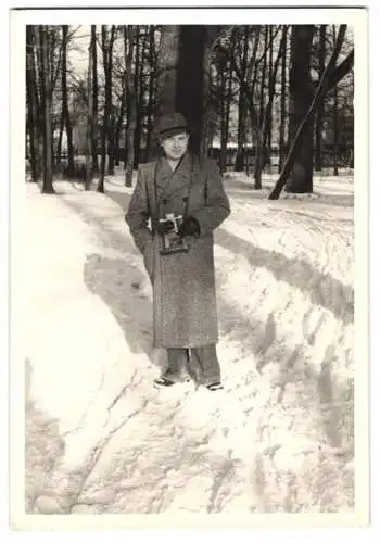 Fotografie unbekannter Fotograf und Ort, junger Mann mit seiner Foto Kamera im Winter