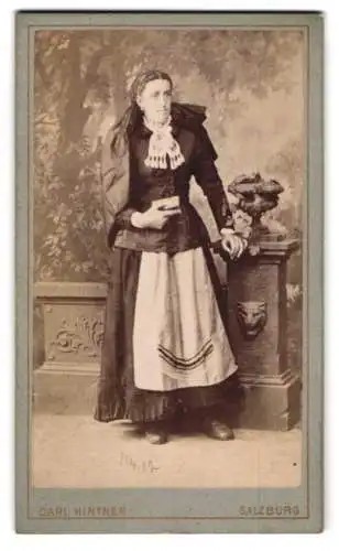 Fotografie Carl Hintner, Salzburg, junge Frau im Trachtenkleid vor einer Studiokulisse