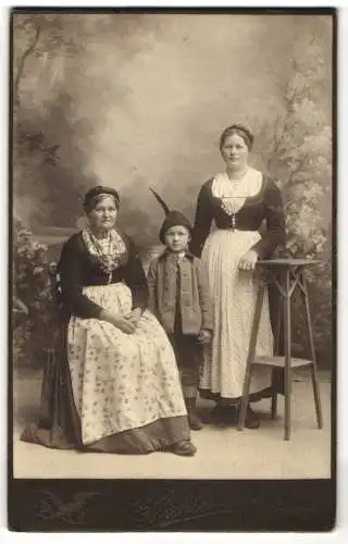 Fotografie Georg Pichler, Hallein, Grossmutter und Mutter in Trachtekleid mit Sohn in Tracht, drei Generationen