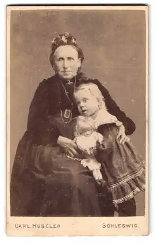 Fotografie Carl Hüseler, Schleswig, Grossmutter mit Ihrer Enkeltochter samt Puppe im Arm