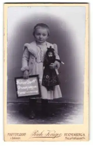 Fotografie Rich. Krüger, Reichenberg i. B., kleines Mädchen mit Puppe im Arm und Schild: Grüss Gott Grosspapa & Grossmama