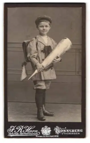 Fotografie J. R. Horn, Sonneberg i. Th., junger Knabe zum Schulanfang mit Zuckertüte und Ranzen