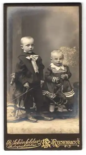 Fotografie R. Schönfelder, Reichenbach i. V., zwei niedliche kleine Kinder mit Schaukelpferd