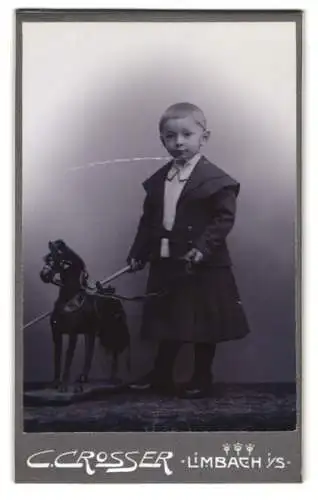 Fotografie C. Crosser, Limbach i. Sa., kleines Mädchen im Kleid mit Schaukelpferd und Topfhaarschnitt
