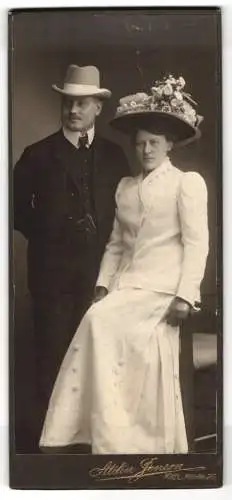 Fotografie Atelier Jensen, Kiel, Frau im weissen Kleid mit Blumenhut und Herr im dunklen Anzug mit Hut