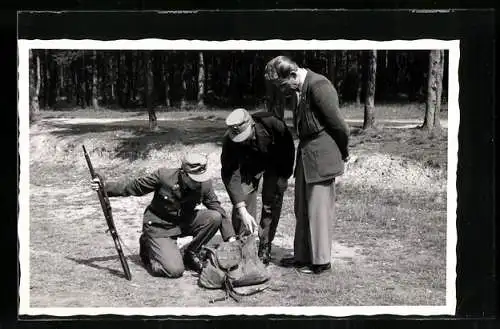 Foto-AK Zwei Zollbeamte kontrollieren die Tasche eines Reisenden an der Grenze