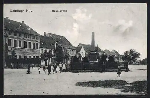 AK Dobrilugk /N.-L., Hauptstrasse mit Gasthof zum deutschen Hause und Denkmal