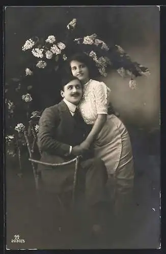 Foto-AK GG Co. Nr. 2030 /5: Ein schmusendes Paar, lächelnd unter einem Blumenarrangement