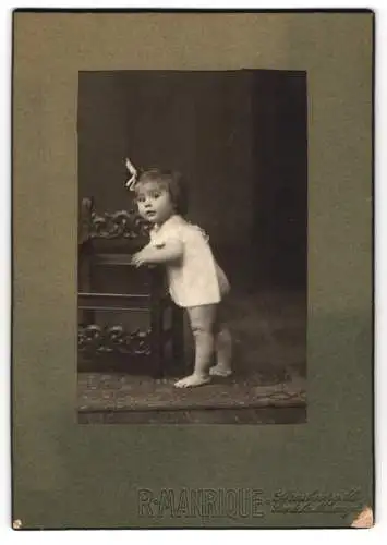 Fotografie R. Manrique, Strasbourg /Als., Rue de la Mésange 3, Kleinkind im weissen Gewand und Schleife im Haar