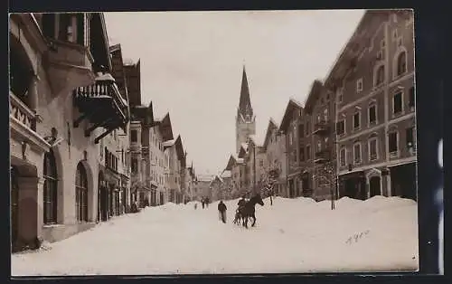 AK Kitzbühel, Strassenpartie mit Pferdeschlitten im Winter, Blick zur Kirche