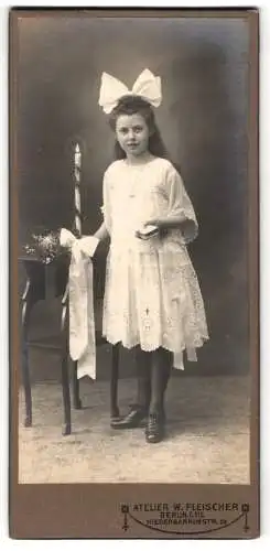 Fotografie W. Fleischer, Berlin, Niederbarnimstr. 24, junges Mädchen zu ihrer Konfirmation mit Kerze und Haarschleife