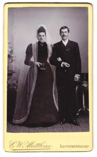 Fotografie E. W. Matthais, Seifhennersdorf, junges Brautpaar im schwarzen Hochzeitskleid und Anzug