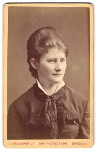 Fotografie N. Raschkow Jr., Breslau, Ohlauerstr. 4, junge Frau im dunklen Kleid mit Schleife