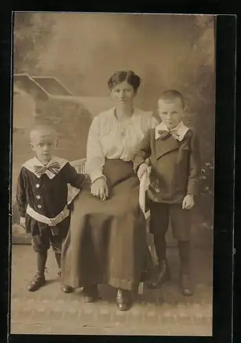 Foto-AK Mutter mit zwei Knaben in einer Studiokulisse