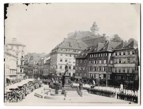 Fotografie unbekannter Fotograf, Ansicht Graz, Prozessionsumzug vor Ladengeschäft Ansichtskarten-Zentrale am Markttag