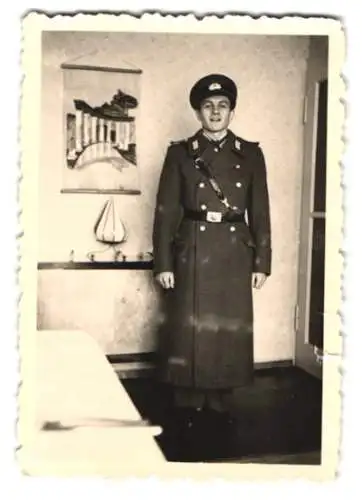 Fotografie Soldat der NVA in uniform mit Schirmmütze & Mantel