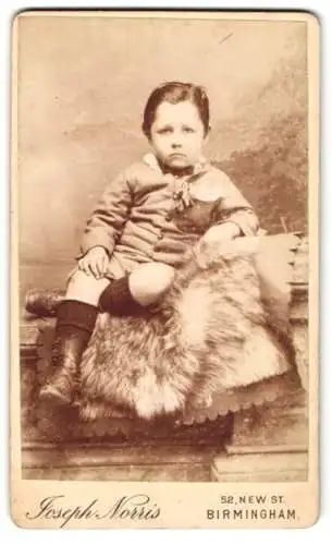 Fotografie Joseph Norris, Birmingham, 52 New St., Kleiner Junge mit überschlagenen Beinen auf Fell