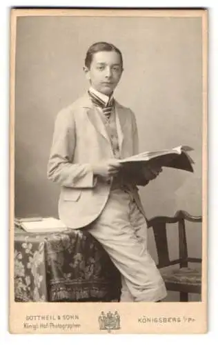 Fotografie Gottheil & Sohn, Königsberg i. Pr., Münzstrasse 6, Junge im Anzug mit aufgeschlagenem Buch