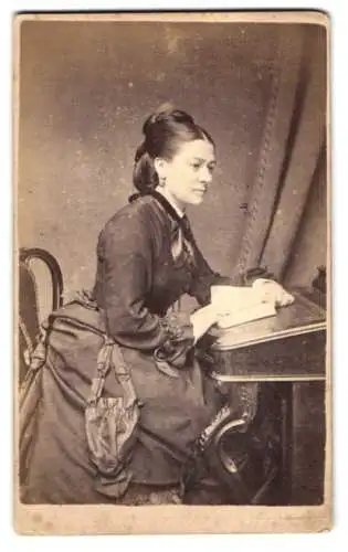 Fotografie Wood & Co., London, 190, Brompton Rd., Junge elegante Dame liest am Pult