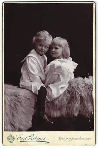 Fotografie Carl Pietzner, Wien, zwei niedliche blonde Kinder auf Fell sitzend
