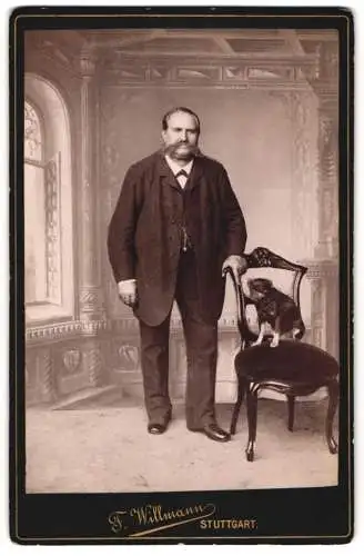 Fotografie F. Willmann, Stuttgart, Herr im Anzug mit Mustasch und seinem Hund auf dem Stuhl