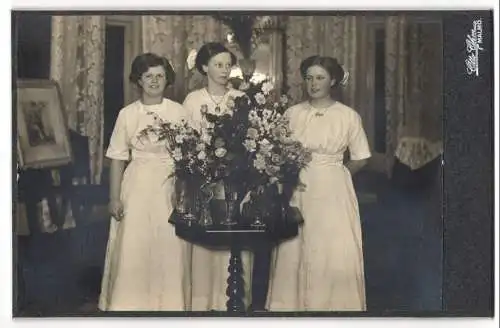 Fotografie Otto Ohm, Malmö, drei junge Frauen in hellen Kleidern hinter Blumenbouquet