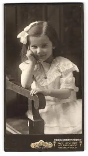 Fotografie Paul Schuppe, Halle / Saale, niedliches kleines Mädchen im weissen Kleid mit Haarschleife, 1912