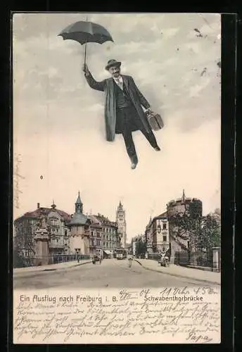 AK Freiburg i. B., Mann fliegt mit Regenschirm über die Schwabenthorbrücke