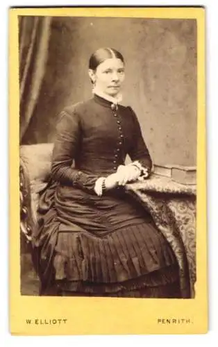 Fotografie W. Elliot, Penrith, 24 Crown Square, Dame in tailliertem Kleid mit hochgeschlossenem Kragen