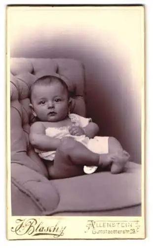 Fotografie J. Blaschy, Allenstein, Guttstaedterstr. 29 c, Süsses Kleinkind im Hemd sitzt auf Sessel